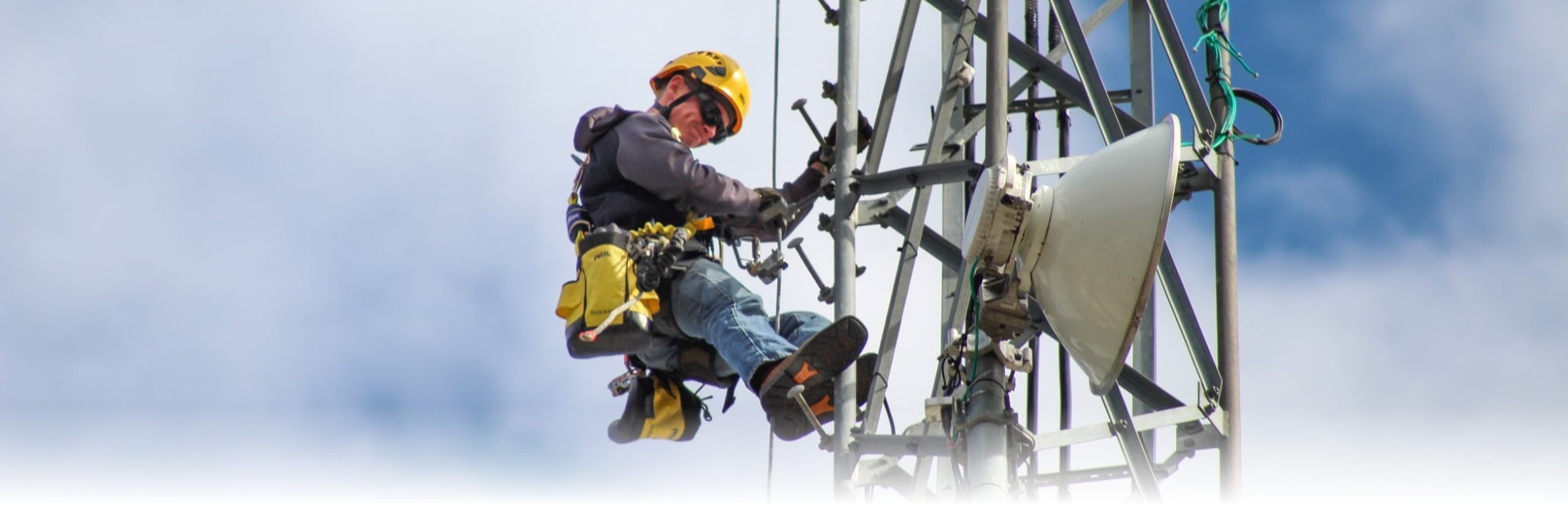 Aerial installer fitting a new microwave waveguide to a tower